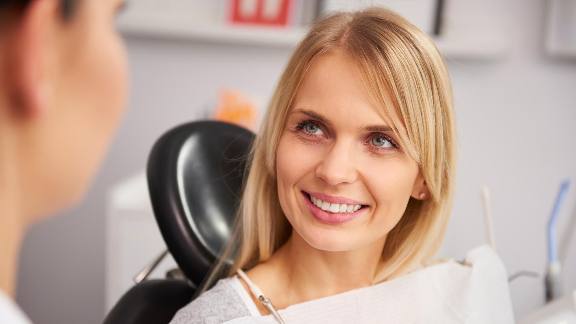 Lachende Frau auf einem Behandlungsstuhl beim Zahnarzt. zahnarzt-muehlacker-ziegenhagel-iStock-1145186546.jpg