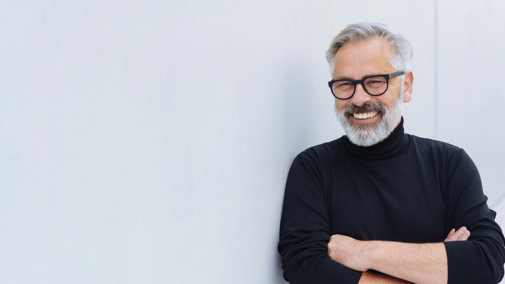 Das Bild zeigt einen Senior mit Brille und verschränkten Armen.  zahnarzt-muehlacker-ziegenhagel-iStock-1073259110.jpg